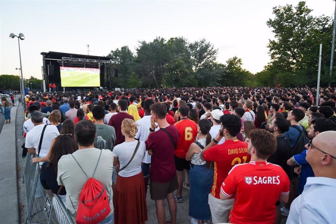 Cientos de aficionados presencian el partido de semifinales de la Eurocopa entre España y Francia desde una pantalla gigante, en Madrid.