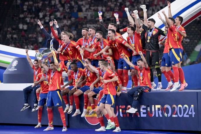 14 July 2024, Berlin: Spain's players celebrate with the European Championship trophy after winning the UEFA Euro 2024 final soccer match against England at the Olympic Stadium. Photo: Federico Gambarini/dpa