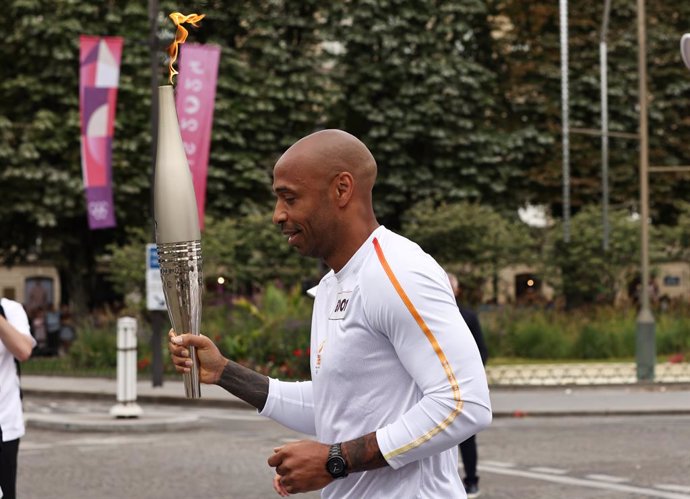 PARIS, July 14, 2024  -- French football Olympics 2024 coach Thierry Henry holds the Olympic torch during the Olympic Games Paris 2024 Torch Relay in Paris, France, July 14, 2024.