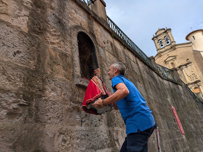 Un operario coloca la imagen de San Fermín propiedad del Ayuntamiento de Pamplona en la hornacina de la cuesta de Santo Domingo tras el final de las fiestas.