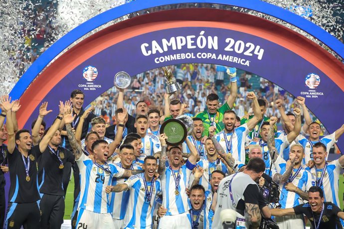 14 July 2024, US, Miami: Argentina's Lionel Messi lifts up the trophy as he celebrates with his team mates after the final whistle of the CONMEBOL Copa America 2024 final soccer match between Argentina and Colombia at Hard Rock Stadium. Photo: Vanessa Car