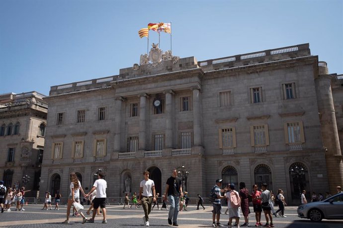 Archivo - Varias personas caminan delante del edificio del Ayuntamiento de Barcelona.