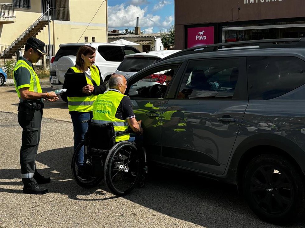 Un voluntario de ASPAYM informa a un conductor durante un control de la Guardia Civil este viernes en Puente Villarente (León).