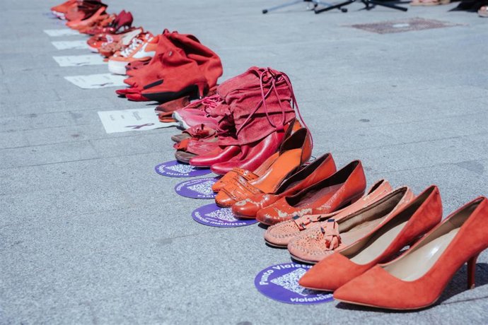 Varios pares de zapatos de color rojo durante un minuto de silencio por la mujer fallecida en Alicante. 