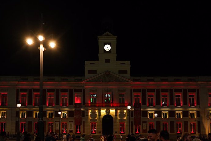 Imagen de la fachada de la Real Casa de Correos iluminada con la bandera de España por la victoria en la Eurocopa