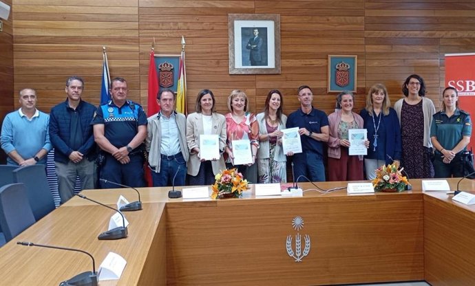 Representantes de las entidades implicadas posan con el protocolo contra la violencia hacia las mujeres suscrito en Noain.