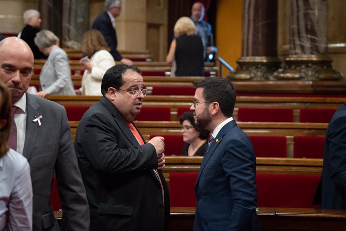 Archivo - El conseller de Interior, Joan Ignasi Elena (i) y el presidente de la Generalitat, Pere Aragonés (d), conversan durante una sesión de control en el Pleno del Parlament, a 19 de octubre de 2022, en Barcelona, Cataluña (España). Aragonès y el Gove