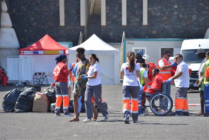 Archivo - Los servicios sanitarios atienden a los migrantes a la llegada de una patera al muelle de La Restinga