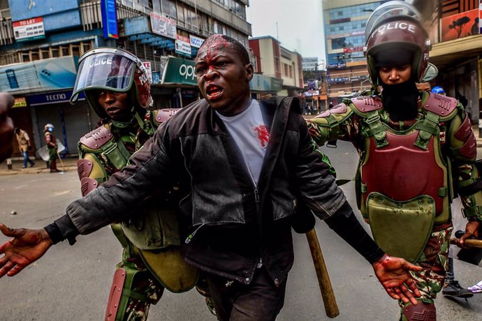 July 2, 2024, Nairobi, Kenya: Riot police help a protester from being beaten by business operators during a demonstration over police killings of people protesting against Kenya's proposed finance bill 2024/2025 in Nairobi.