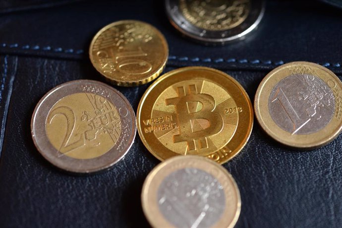 Archivo - A Bitcoin and euro coins can be seen during the 'Bitcoin Exchange Berlin' at the Betahaus. Photo: Jens Kalaene/dpa-Zentralbild/dpa