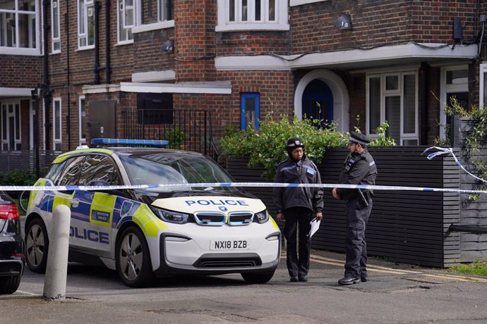 Archivo - 07 April 2024, United Kingdom, London: Police officers stand near the scene, where a woman was found unresponsive in a car in Hackney. A man has been arrested on suspicion of her murder. Photo: Jordan Pettitt/PA Wire/dpa