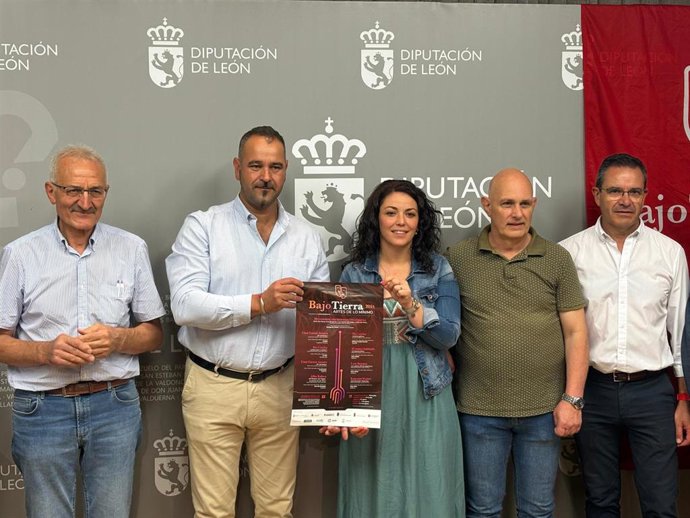 El responsable del ILC, Emilio Martínez, sujeta el cartel del evento, junto a los alcaldes de los municipios que participan en el certamen.