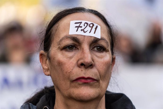 Archivo - Una mujer lleva un papel en la frente con el número de residentes muertos en la pandemia durante una manifestación en memoria de los residentes fallecidos en la primera ola de la pandemia.