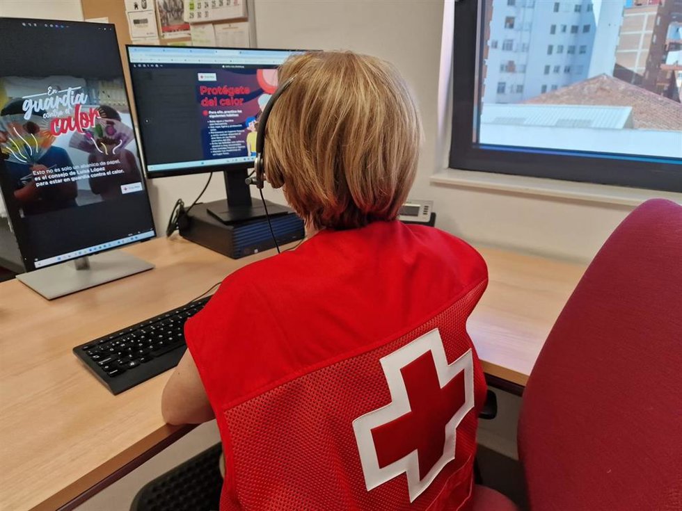 Voluntario durante una llamada a una de las personas usuarias de Cruz Roja para prevenir los efectos de la ola de calor.