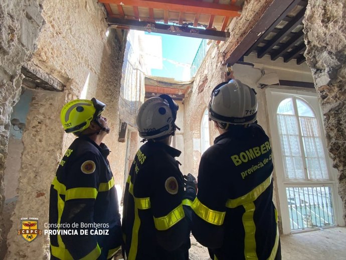 Efectivos de bomberos de Cádiz inspeccionando el forjado de la vivienda que se ha derrumbado en la calle Cobos de la capital.