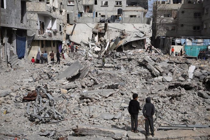 Archivo - Palestinos frente a un edificio destruido por un bombardeo del Ejército de Israel contra la ciudad de Rafá, en el sur de la Franja de Gaza (archivo)