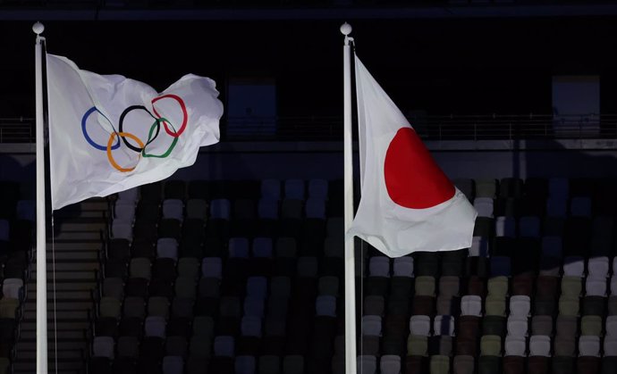 Archivo - 23 July 2021, Japan, Tokyo: The Olympic flag flies next to the Japanese flag during the opening ceremony of the Tokyo 2020 Olympic Games at the Olympic Stadium. The ceremony is attended by only 950 VIPs due to the coronavirus pandemic. Photo: Ja