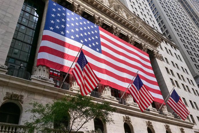 04 July 2024, US, New York: NY Stock Exchange shows the red white and blue on Independence Day with giant US flag. Photo: Milo Hess/ZUMA Press Wire/dpa