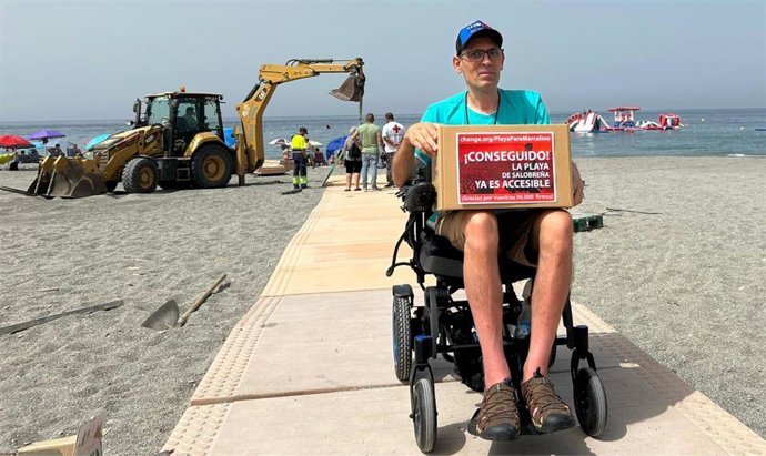 Archivo - Marcelino Torres, con la caja de firmas recogidas en Change.Org y junto a las obras de ampliación de la pasarela de la playa de Salobreña.
