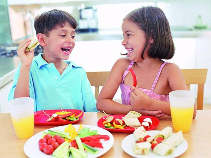 Niños comiendo frutas y verduras