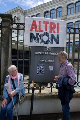 Dos personas durante una nueva protesta contra la empresa de celulosa Altri, en la puerta principal de la Xunta de Galicia, a 30 de junio de 2024, en Santiago de Compostela, A Coruña, Galicia.