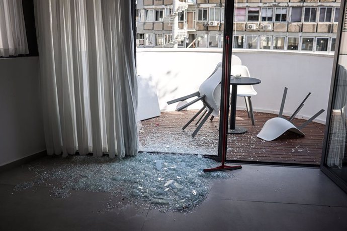 19 July 2024, Israel, Tel Aviv: A view of a damaged building in the area of an explosion as Israeli policemen search the scene. One person was killed and eight people injured following a loud explosion near a branch of the US embassy in Tel Aviv early on 