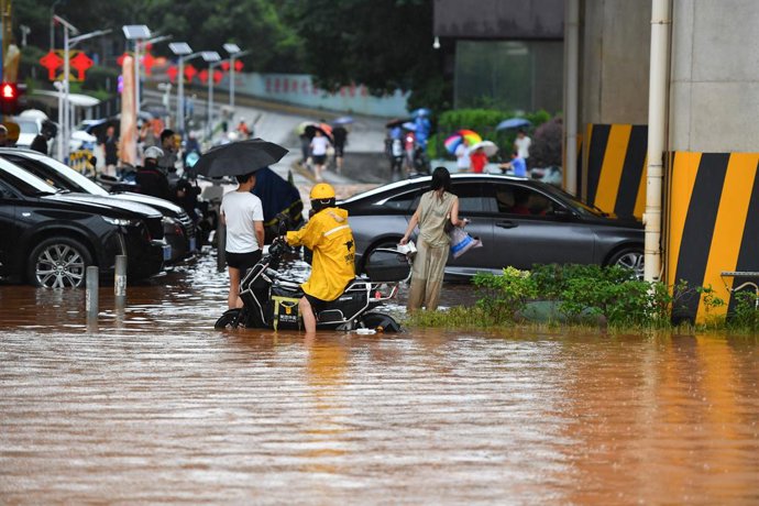 CHANGSHA, June 24, 2024  -- People wades through a waterlogged road in Changsha, central China's Hunan Province, June 24, 2024. On Monday, Changsha of central China's Hunan Province saw 15 waterlogged roads after intense rain. The city has launched a Le