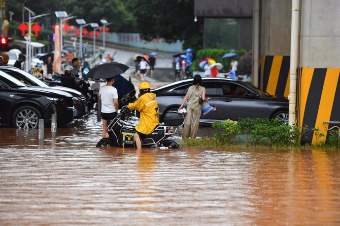 CHANGSHA, June 24, 2024  -- People wades through a waterlogged road in Changsha, central China's Hunan Province, June 24, 2024. On Monday, Changsha of central China's Hunan Province saw 15 waterlogged roads after intense rain. The city has launched a Leve