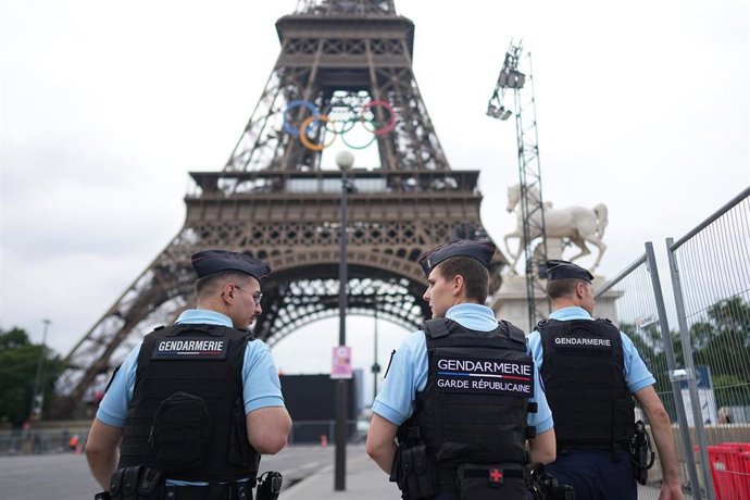 21 July 2024, France, Paris: Police officers walk along the Eiffel Tower ahead of Paris 2024 Olympic Games. Photo: Michael Kappeler/dpa