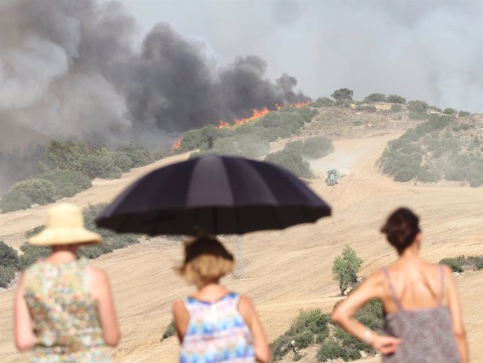 Archivo - Varios civiles observan la progresión del incendio, a 24 de agosto de 2023, en Artajona, Navarra (España). Bomberos de los parques de Tafalla, Cordovilla, Peralta y Estella, dos helicópteros y dos aviones de carga en tierra intervienen en el inc