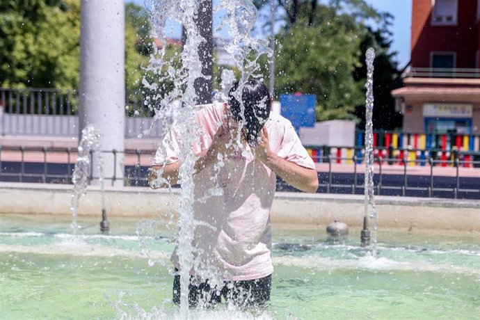 Archivo - Una persona se refresca en una fuente,