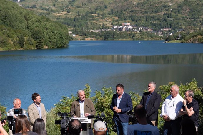 El presidente del Gobierno de Aragón, Jorge Azcón, con el presidente de la DPH, Isaac Claver, y alcaldes del Pirineo, junto al embalse de Lanuza.