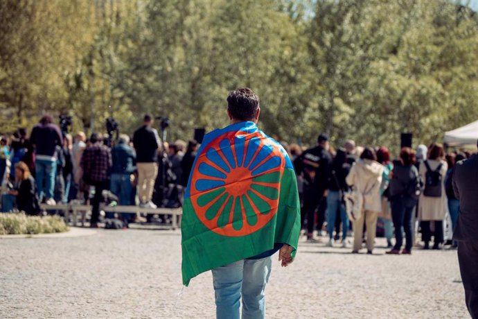 Archivo - Una persona con una bandera gitana a su espalda durante el acto conmemorativo del Día Internacional del Pueblo Gitano 