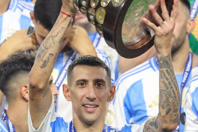 14 July 2024, US, Miami: Argentina's Angel Di Maria lifts up the trophy as he celebrates with his team mates after the final whistle of the CONMEBOL Copa America 2024 final soccer match between Argentina and Colombia at Hard Rock Stadium. 