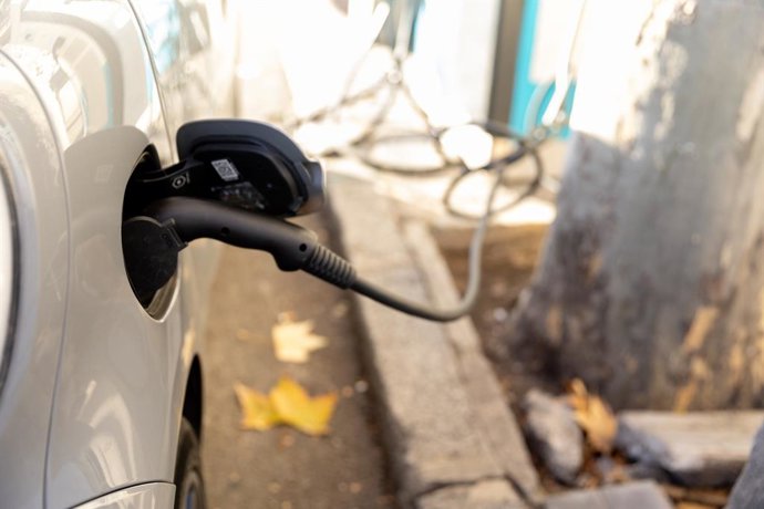 Archivo - Un coche enchufado en un punto de carga, a 19 de diciembre de 2023, en Madrid (España).  