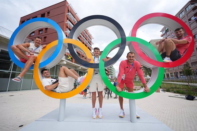 23 July 2024, France, Paris: Germany volleyball players (L-R) Jan Zimmermann, Moritz Reichert, Johannes Tille, Moritz Karlitzek, Julian Zenger pose in the Olympic Village of athletes in the Olympic rings, ahead of the Olympic Games Paris 2024. Photo: Mich