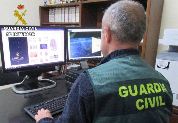 Archivo - Un guardia civil en un ordenador. Archivo.