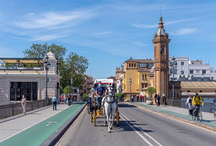 Archivo - Un cochero por el puente de Triana.