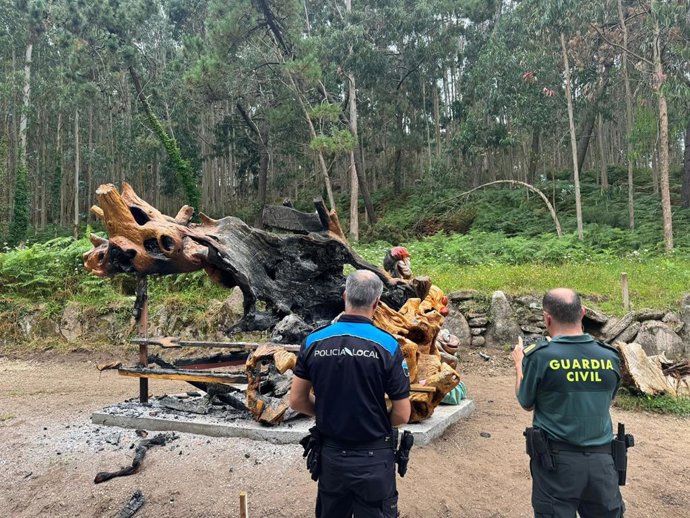 Agentes de la Policía Local y de la Guardia Civil de Burela (Lugo) inspeccionan el estado del monumento escultórico tallado en un castaño centenario a las afueras de la localidad vandalizado este miércoles. En Burela (Lugo), a 24 de julio de 2024.