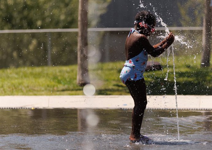Archivo - Una niña juega en una fuente en Madrid Río, 