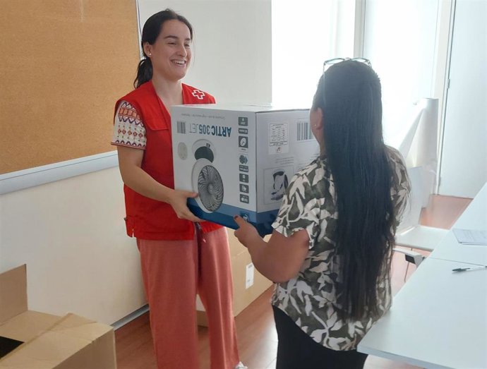 Una voluntaria de Cruz Roja entrega un ventilador.