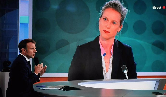 23 July 2024, France, Paris: A photo shows a television screen on which French President Emmanuel Macron is giving a live interview, while a portrait of Lucie Castets, the candidate of the "Nouveau Front Populaire" for prime minister, can be seen on a gia