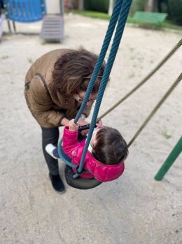 Una abuela y su nieta juegan en un columpio en el parque