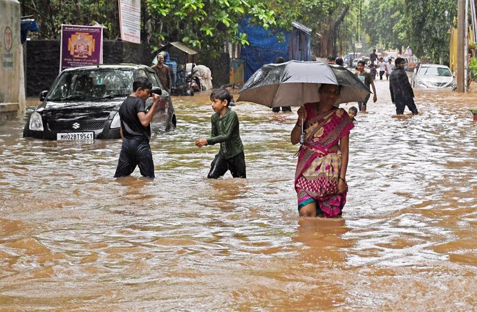July 21, 2024, Mumbai, Maharashtra, India: A woman holding an umbrella walks on a street flooded with water due to heavy rain in Mumbai. Citizens are advised to stay indoors and venture out only in case of an emergency as heavy rains lashed throughout the