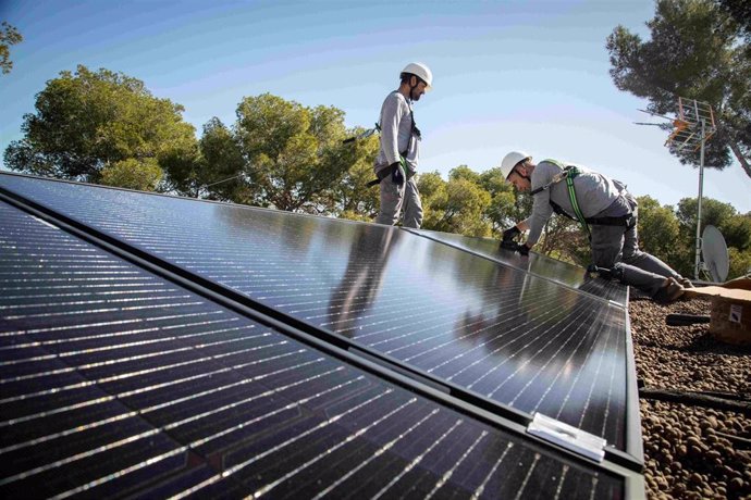 Técnicos instalando placas solares.