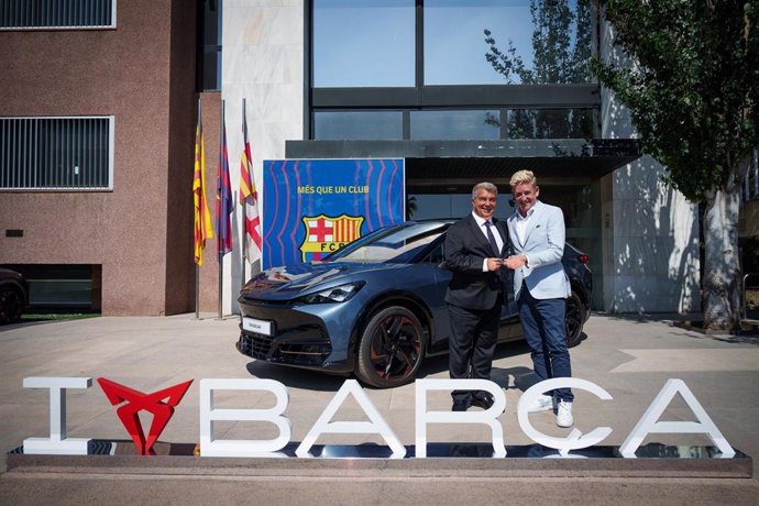 El presidente del FC Barcelonam Joan Laporta, y el CEO de CUPRA, Wayne Griffiths, posan delante del CUPRA Tavascan que la marca ha regalado al presidente blaugrana, delante de las oficinas del club