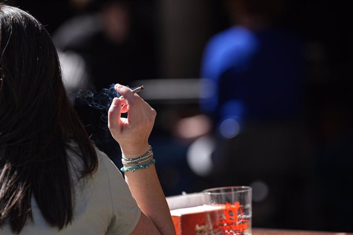 Archivo - Una persona fumando en una terraza. 