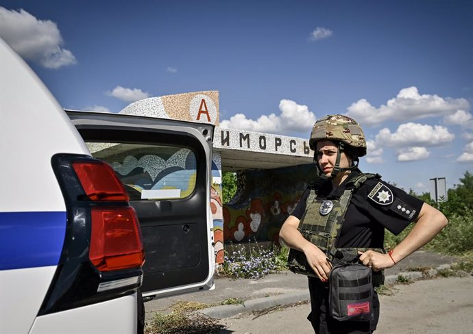 June 28, 2024, Zaporizhzhia Region, Ukraine: ZAPORIZHZHIA REGION, UKRAINE - JUNE 28, 2024 - A police officer from an evacuation group puts on personal protective gear on the way to the rural settlement of Stepnohirsk that is shelled daily by Russian troop