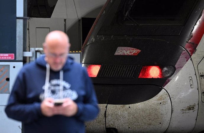 26 July 2024, France, Paris: A traveller stands in front of an SNCF train at Gare Montparnasse station. A few hours before the opening of the Olympic Games in Paris, unknown persons carried out arson attacks on several facilities on the French high-speed 