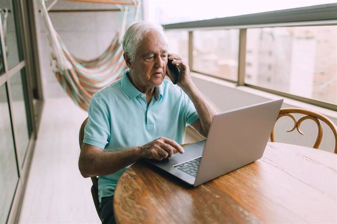 Una persona mayor con un portatil durante el período vacacional